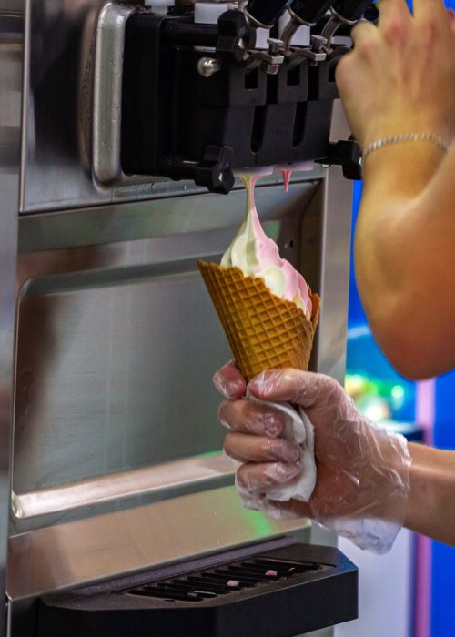 Preparation of creamy fruit ice cream from ice cream machine in shopping mall